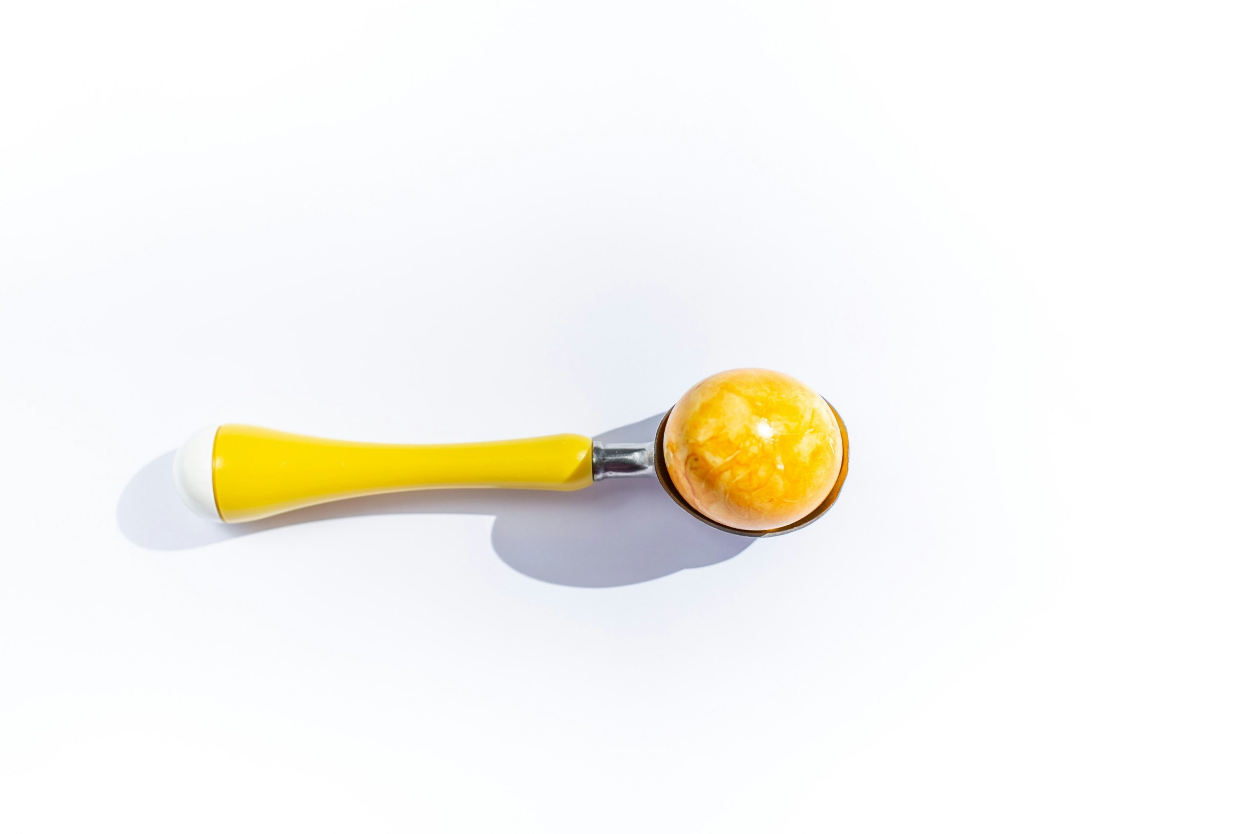 A playful golden retriever holding a squeaky toy tennis ball