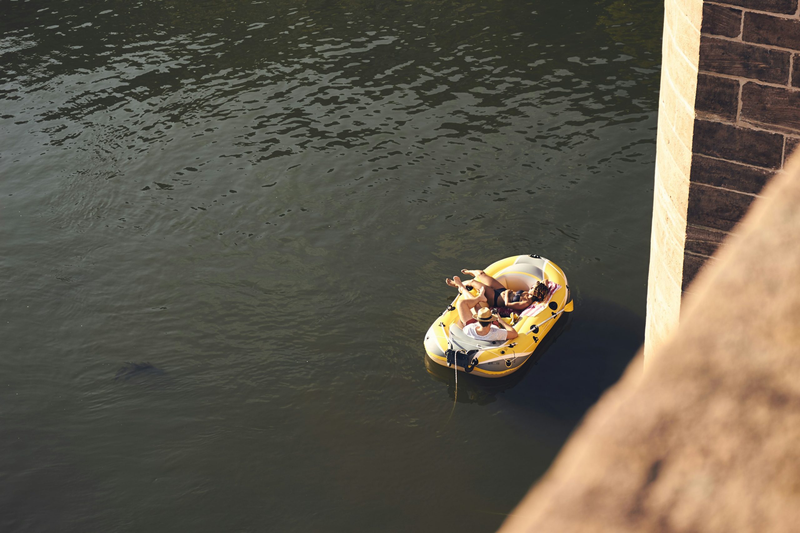 A trainer working with a sitting Labrador using a bright yellow tug toy