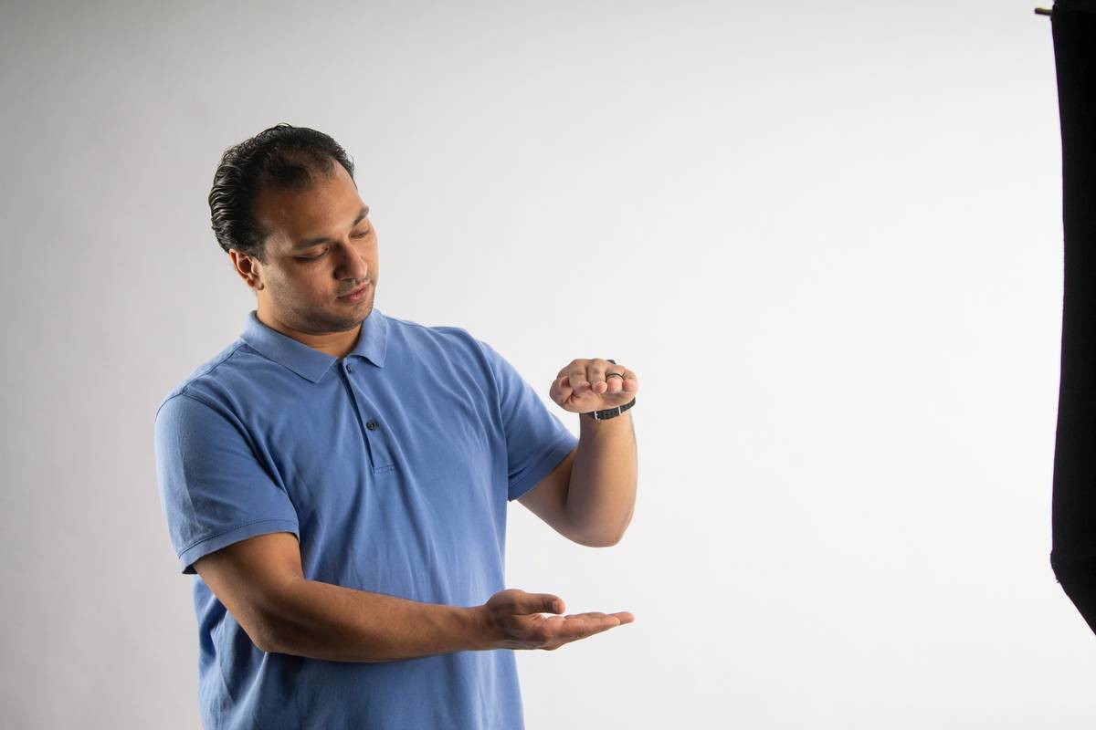 Trainer demonstrating hand signals for sit command during training session.
